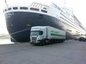 HSF Logistics articulated lorry beside the Queen Mary 2 at port — part of Gareth Wildman’s experience before founding Transcom National Training